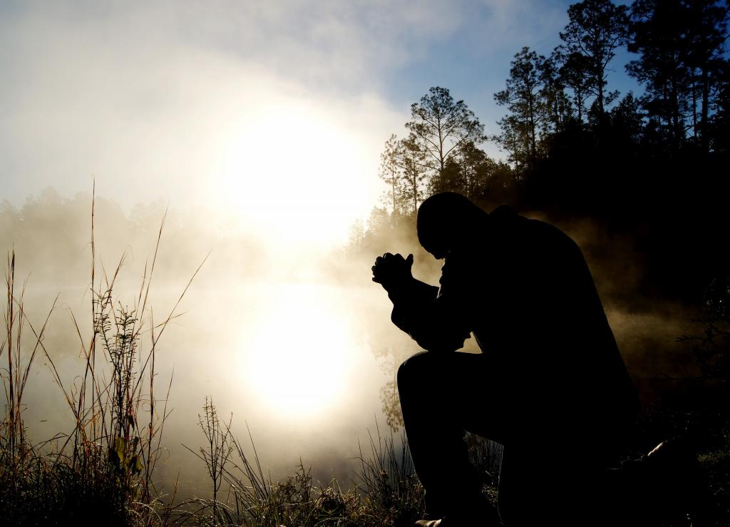 Человек молится ранним утром.